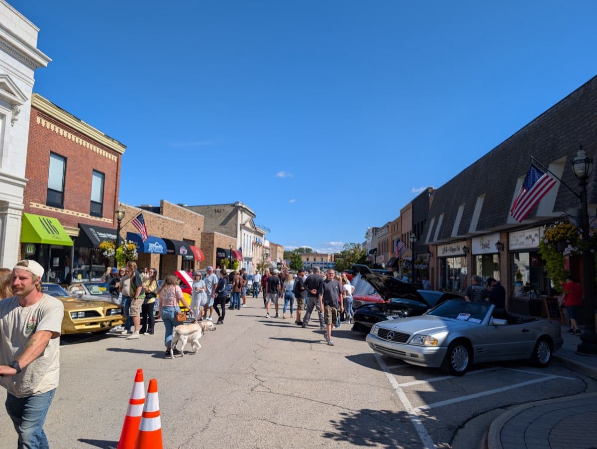 Crowds walking downtown Crystal Lake lined with show cars